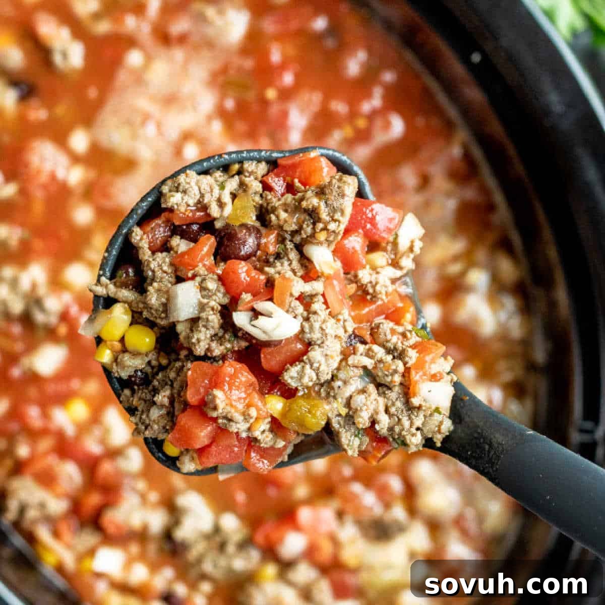 A close-up of the uncooked ingredients for Slow Cooker Taco Soup in a large slow cooker.