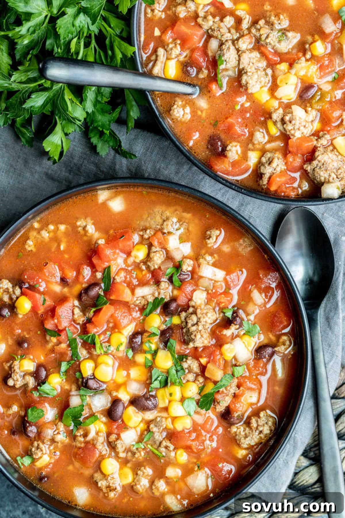 Two black bowls filled with steaming Slow Cooker Taco Soup, ready to enjoy.