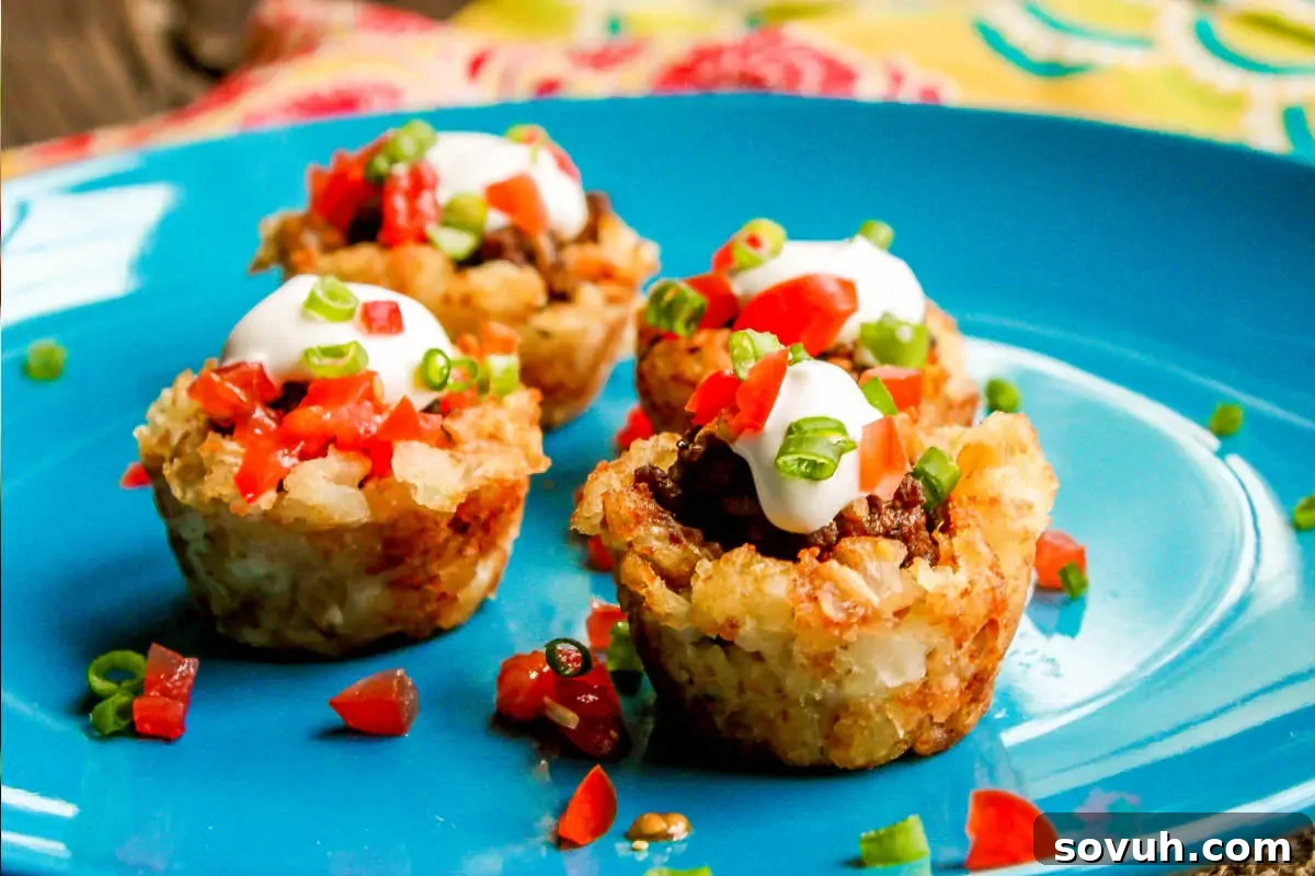 Three perfectly stuffed rice cups, generously topped with creamy sour cream and garnished with finely diced tomatoes and fresh green onions, all elegantly served on a bright blue plate.