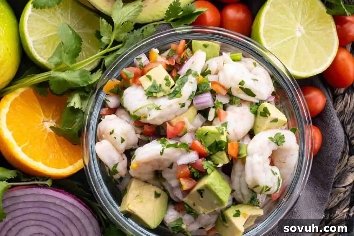 Bowl of shrimp ceviche with avocado, tomatoes, onions, cilantro, and lime on a rustic tabletop surrounded by fresh ingredients.