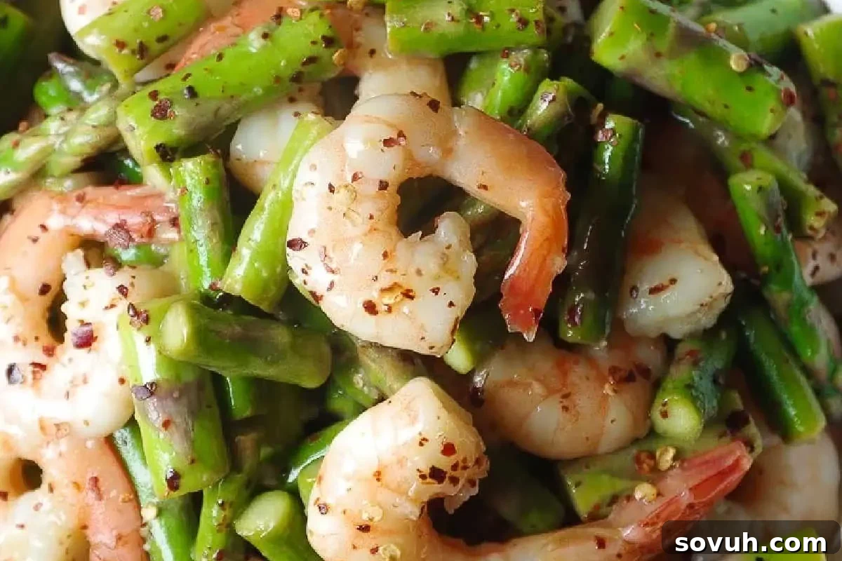 Close-up of a shrimp and asparagus stir-fry seasoned with spices.