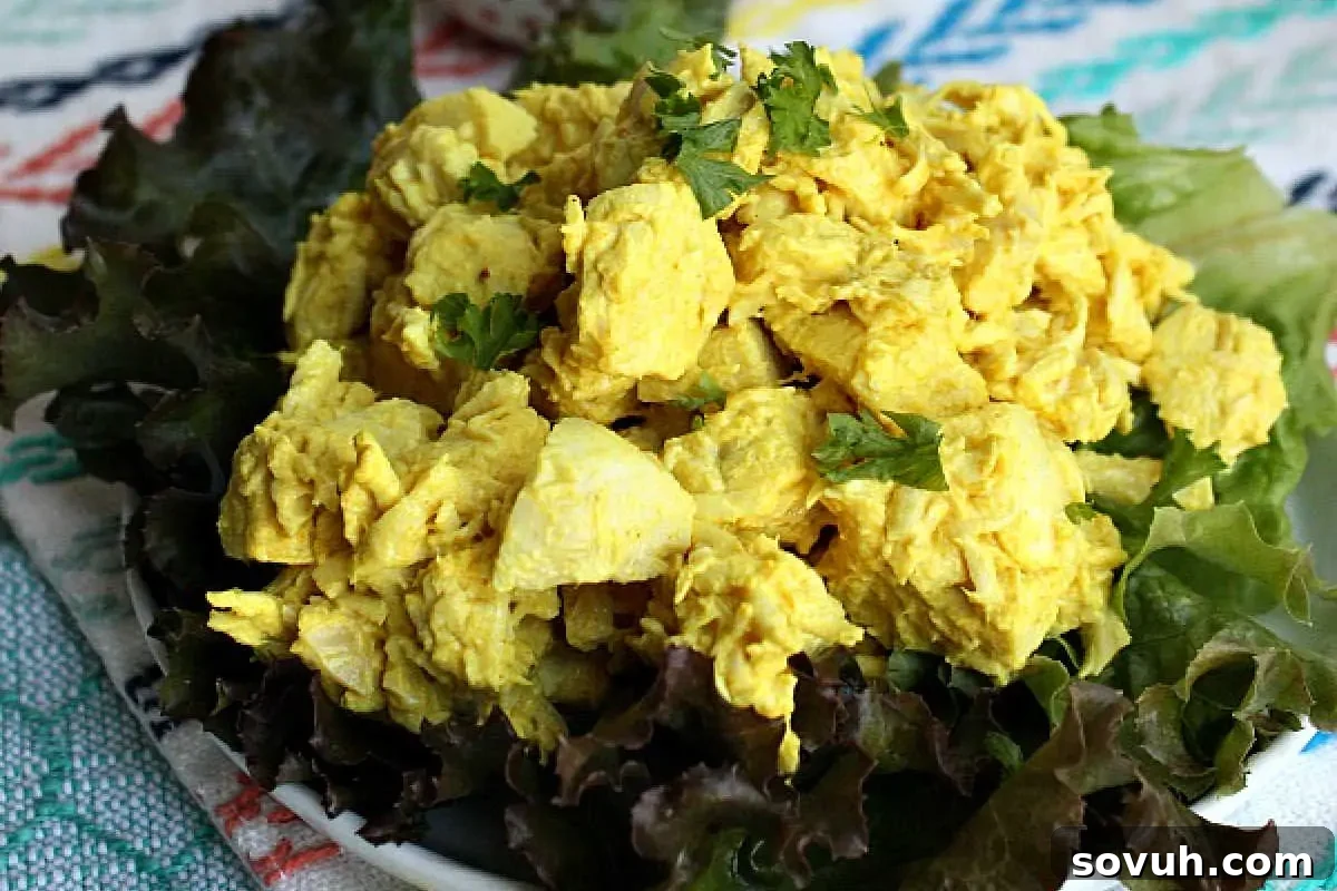 A bowl of scrambled eggs garnished with fresh parsley, served on a bed of dark lettuce leaves.
