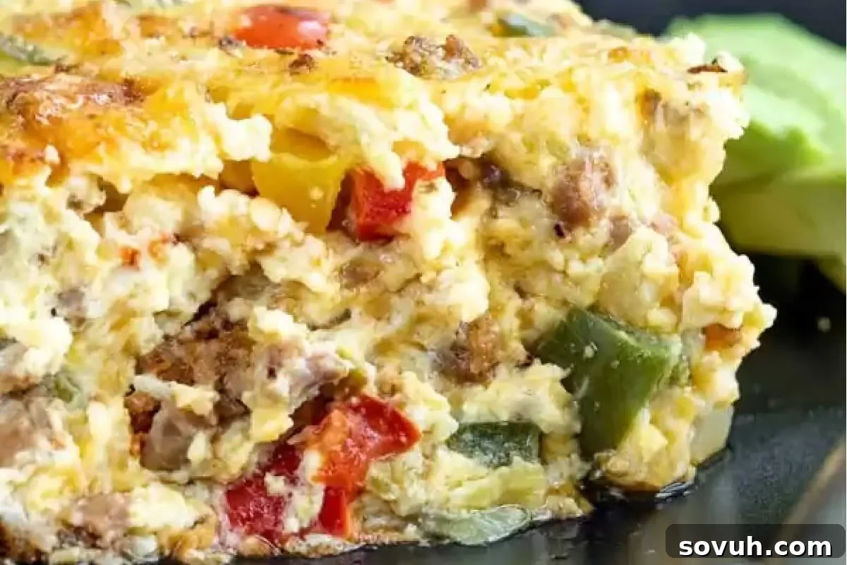 A close-up image of a colorful vegetable and cheese frittata with visible pieces of red bell pepper, zucchini, and egg.