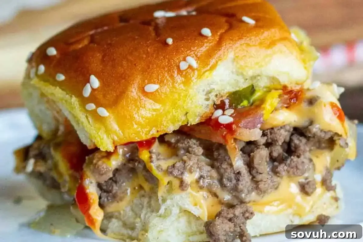 Irresistible Bacon Cheeseburger Slider, featuring a juicy ground beef patty, crisp bacon, melted cheddar cheese, and crunchy pickles on a soft sesame seed bun, ready to be enjoyed.