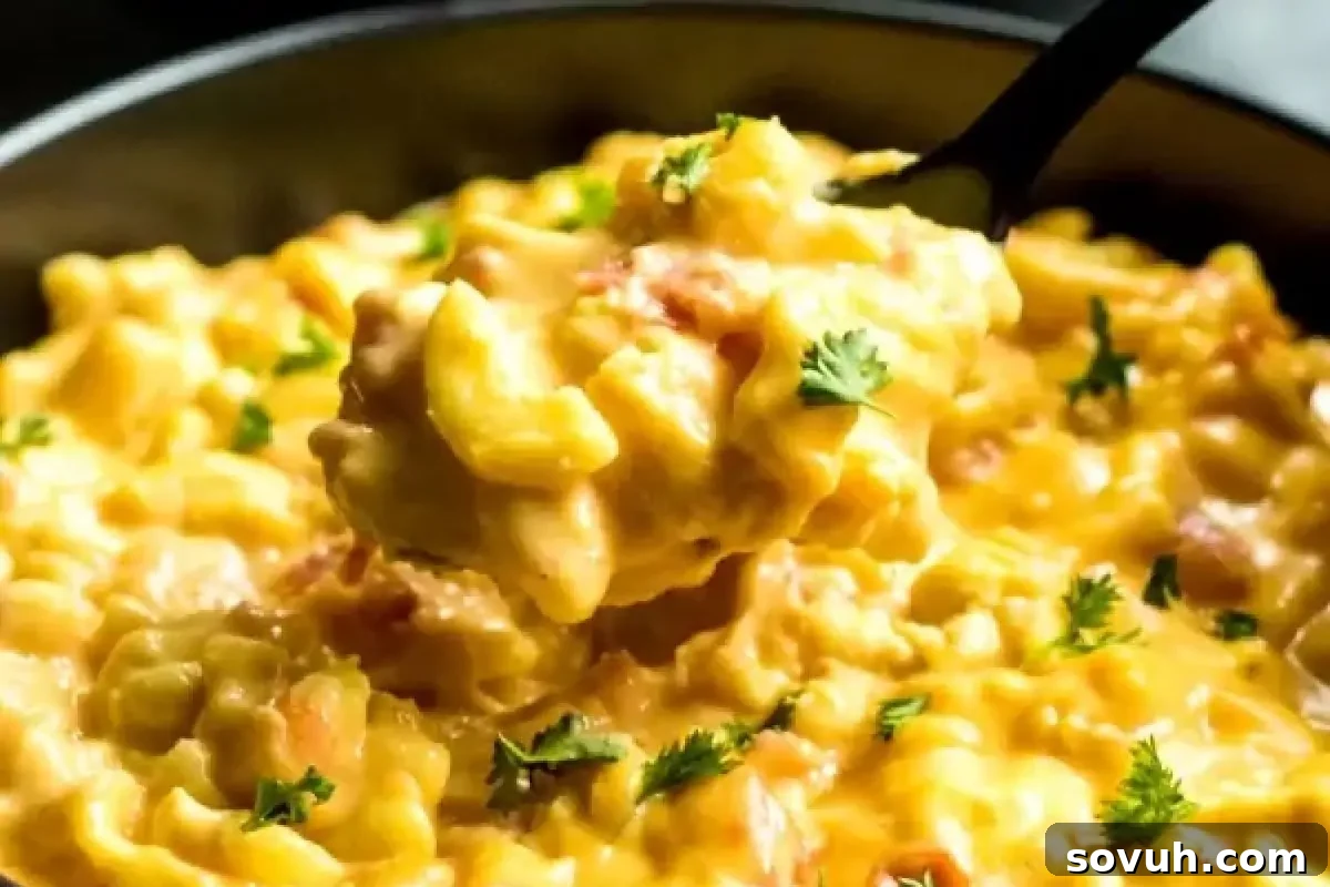 A close-up of incredibly creamy macaroni and cheese, generously garnished with freshly chopped parsley, with a spoon lifting a portion from a bowl, showcasing its rich texture and flavor.