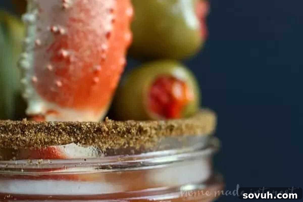 A close-up of a dramatically garnished cocktail, featuring a prominent crab leg, two vibrant olives, and a meticulously coarse salt-rimmed glass, against a subtly blurred background.