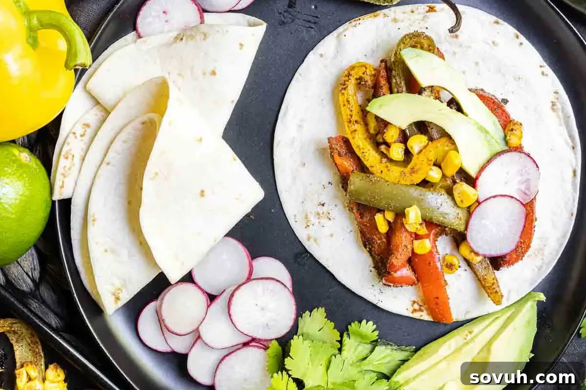 A tortilla filled with grilled vegetables, corn, and avocado slices on a plate, surrounded by sliced radishes, avocado, and cilantro.