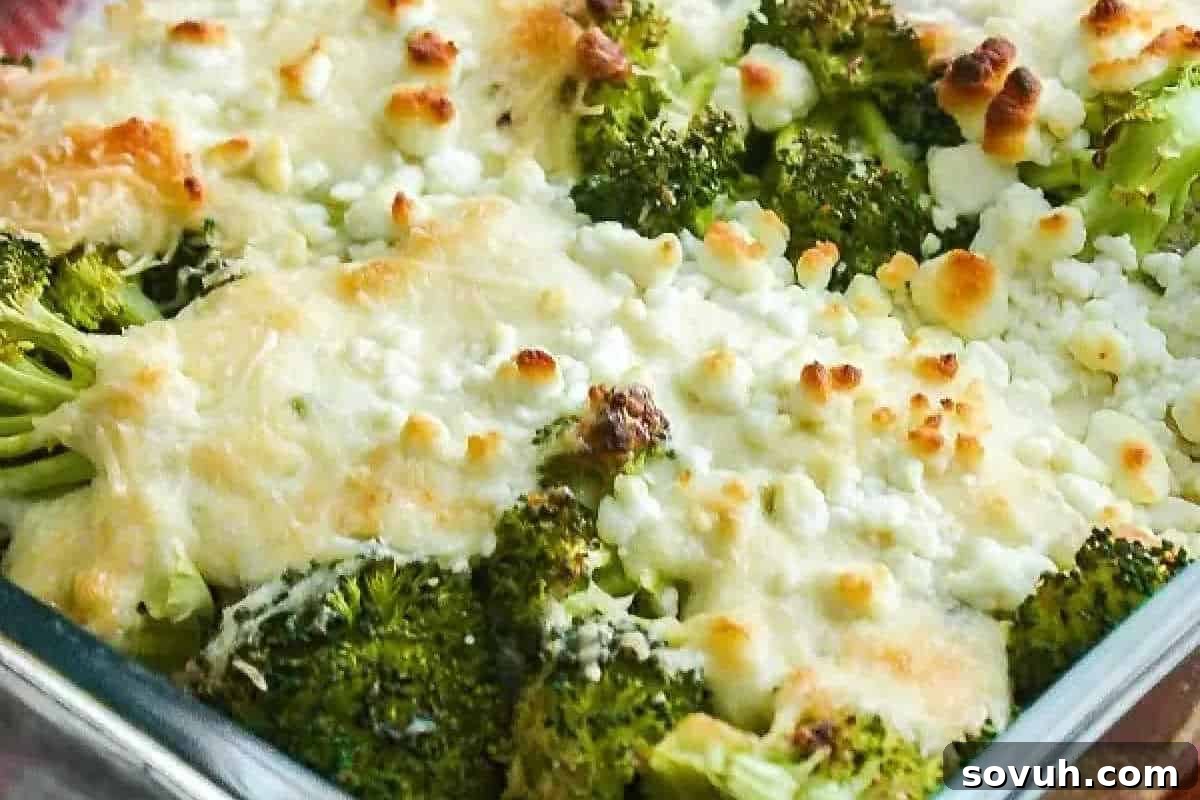 A close-up of a beautifully baked broccoli dish in a clear glass baking dish, generously topped with melted golden-brown cheese and appealing browned spots.