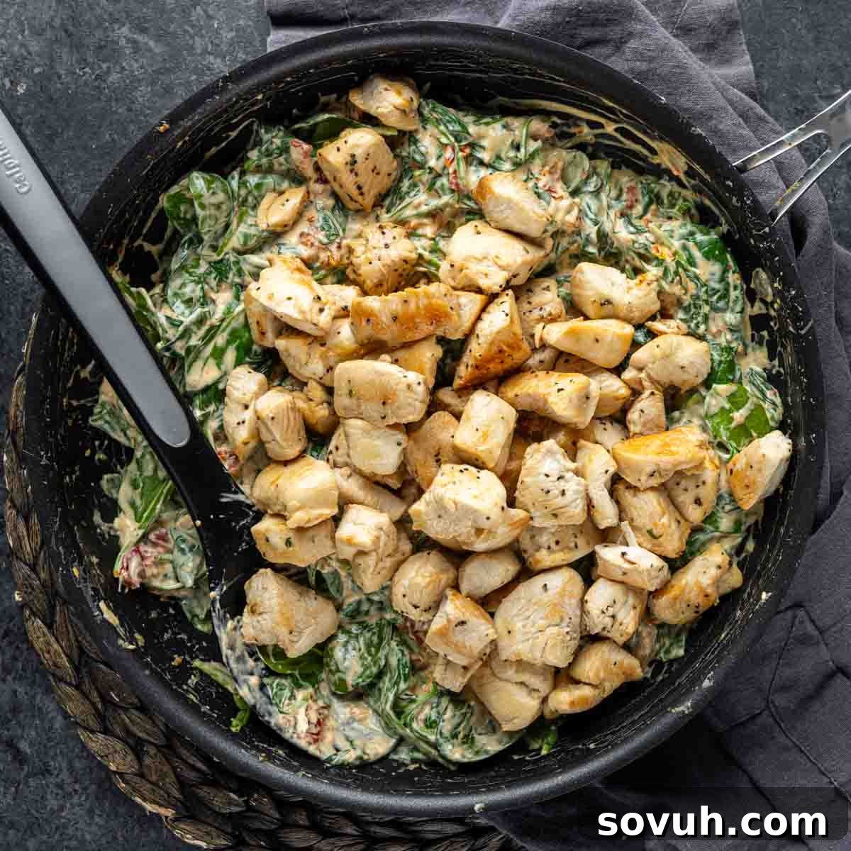Succulent, cooked diced chicken breast is returned to the creamy Chicken Florentine sauce, ready to be combined with pasta for a complete meal.