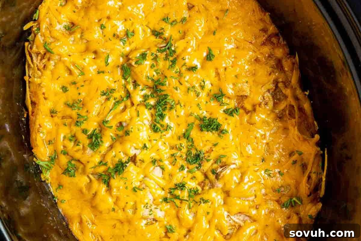 A casserole dish filled with melted cheese and garnished with chopped parsley on top.