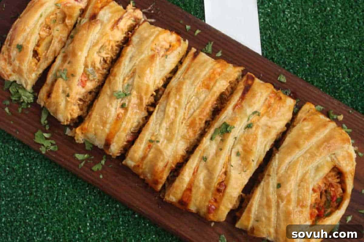 A sliced, golden-brown puff pastry filled with a savory mixture is displayed on a wooden board, garnished with chopped herbs.