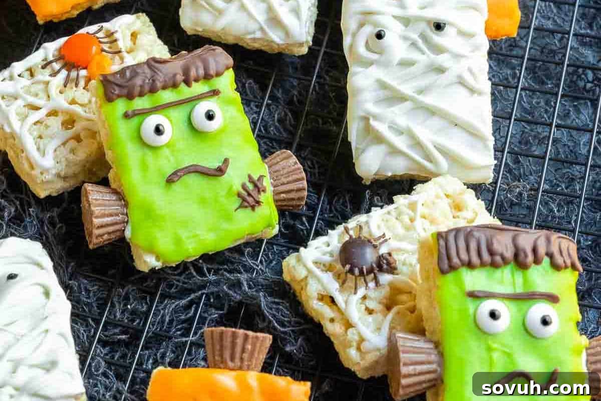 Colorful Halloween-themed Rice Krispies Treats, creatively shaped and decorated like Frankenstein's monster and mummies, proudly displayed on a cooling rack, ready for a spooky celebration.