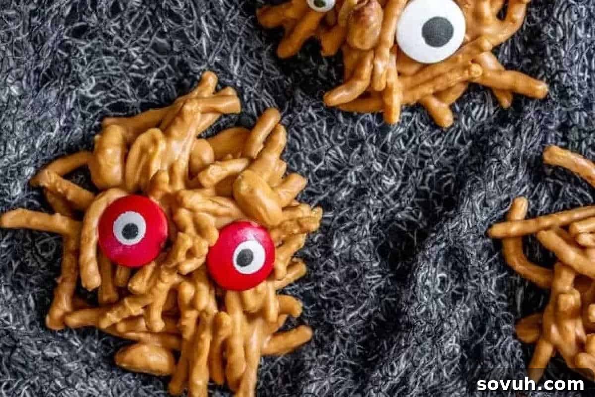 Crunchy, no-bake treats resembling adorable googly-eyed spiders, artfully arranged on a textured dark fabric, showcasing their unique and spooky appeal for Halloween.