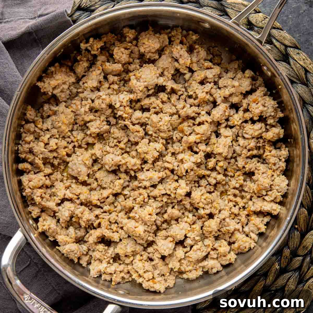 A close-up of crumbled, browned pork sausage in a pan, ready for the next step of the casserole recipe.