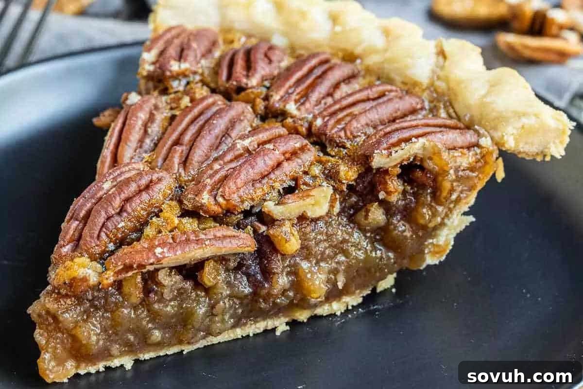 An irresistible slice of Southern Pecan Pie, artfully presented on a black plate, revealing its perfectly flaky crust, rich and gooey filling, and a generous topping of plump whole pecans, symbolizing the ultimate holiday indulgence.
