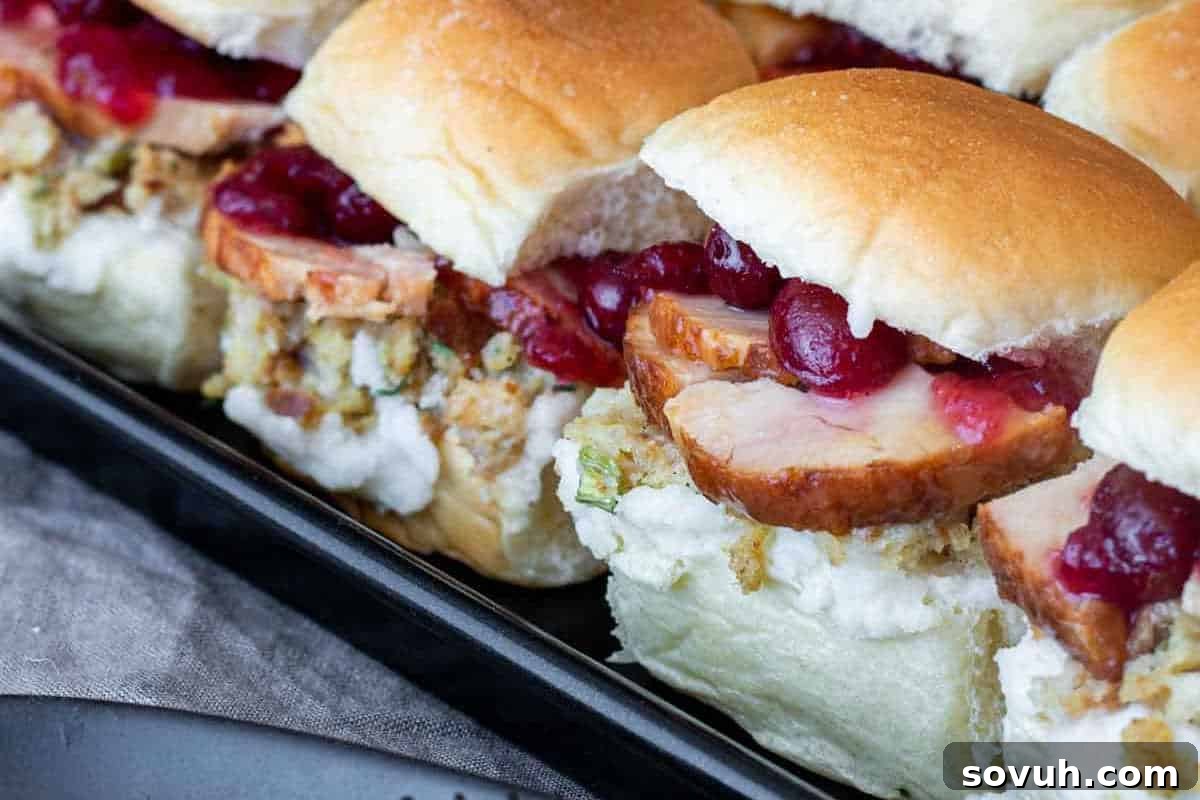 An array of delicious Thanksgiving Leftovers Sliders, featuring tender turkey, sweet cranberry sauce, and savory stuffing, all nestled on small, soft buns in a rustic baking dish.