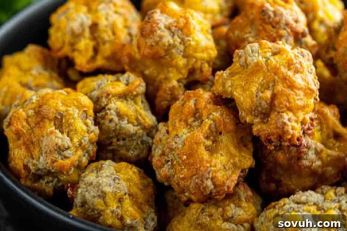 A rustic black bowl overflowing with golden-brown, cheesy sausage balls, showcasing their crispy, savory texture, ready to be enjoyed as a snack or appetizer.