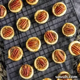 Mini pecan pies on a cooling rack.