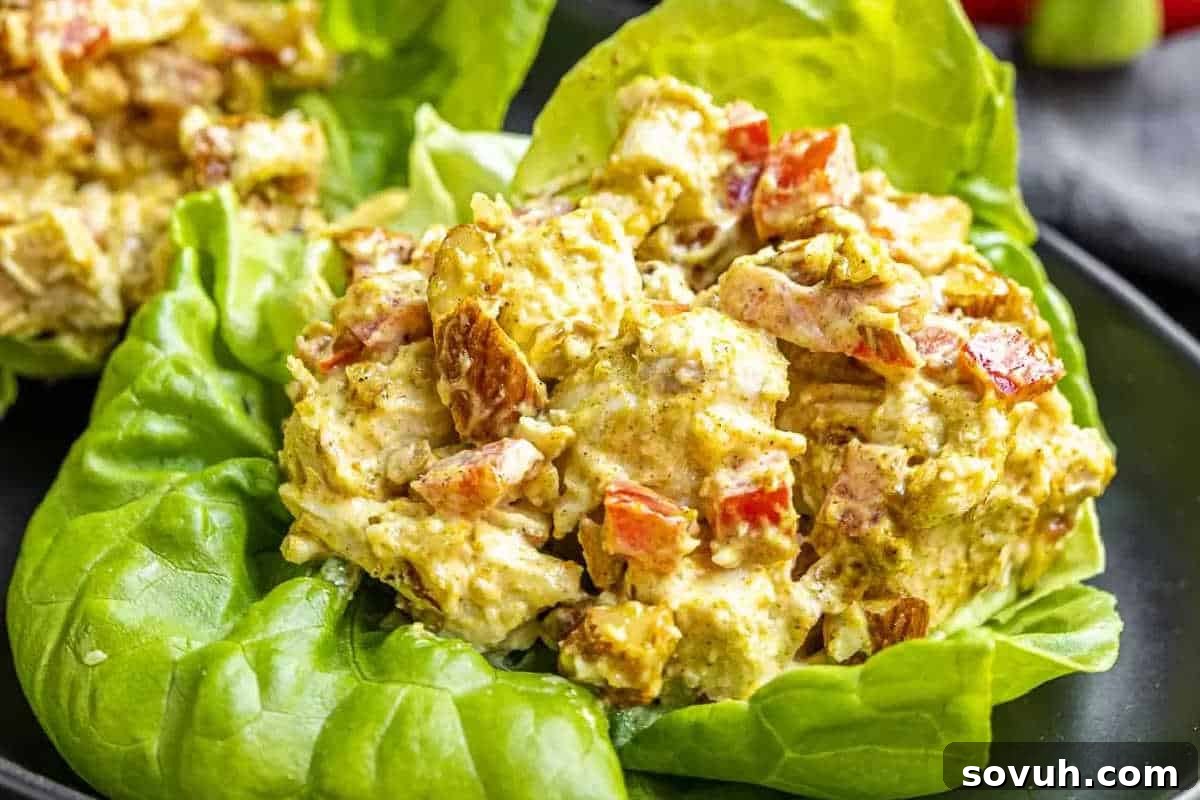 Chicken salad with diced tomatoes served on a bed of lettuce.