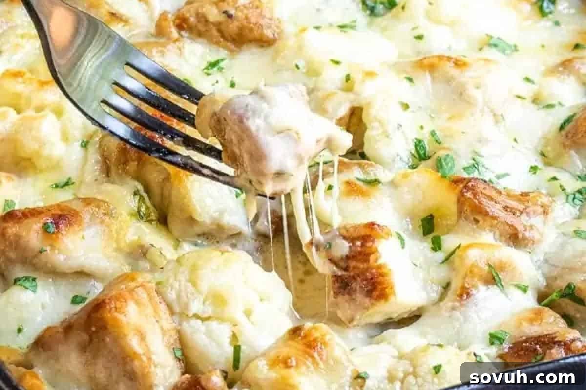 A fork gracefully lifts a piece of cheesy, golden-baked gnocchi, garnished with a sprinkle of freshly chopped herbs, showcasing its rich texture.