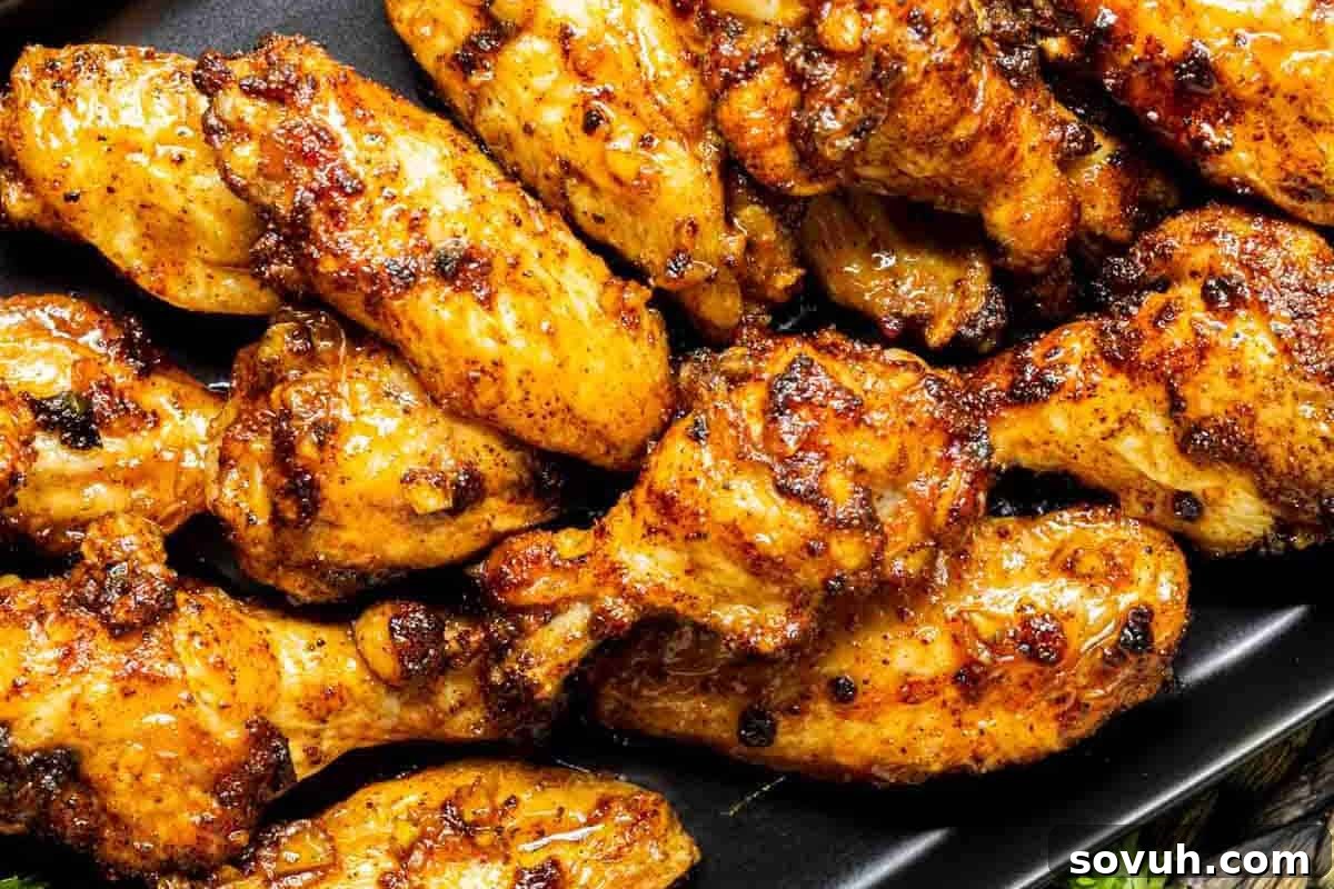 A platter of seasoned, grilled chicken wings arranged closely together.