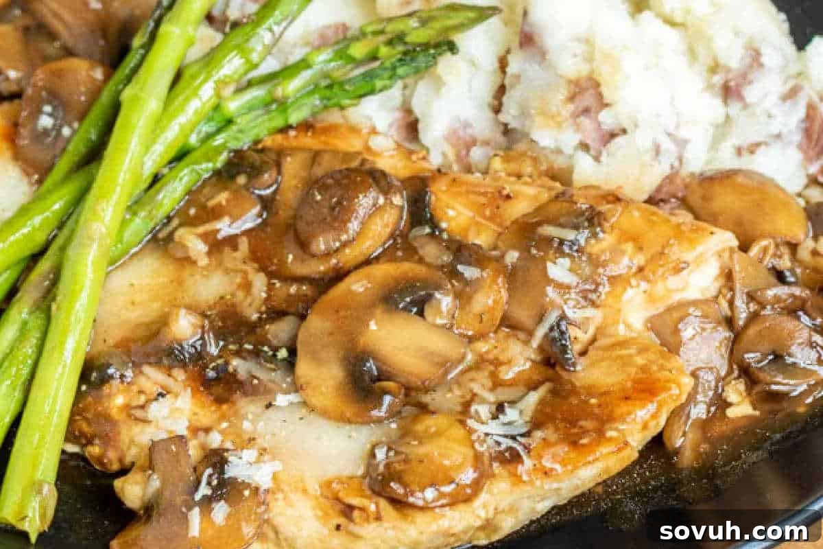 Chicken marsala with mushrooms and asparagus, served alongside mashed potatoes, presenting a restaurant-quality meal.