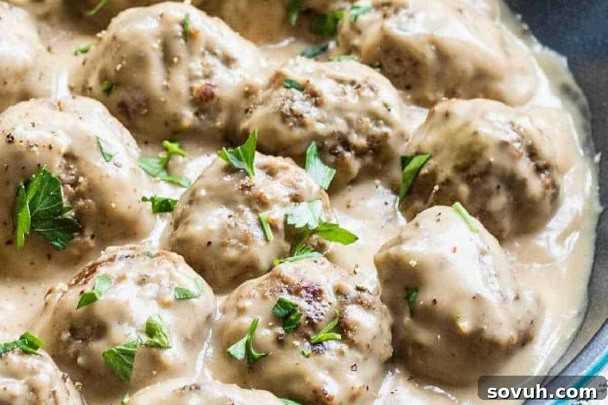 Creamy Swedish meatballs served in a rustic bowl, generously coated in a rich, velvety brown sauce and garnished with a sprinkle of fresh chopped parsley.