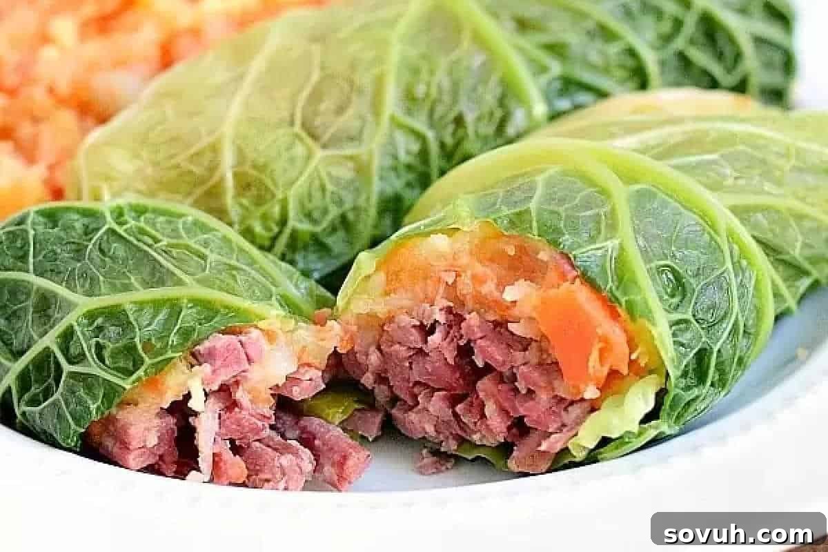 Delicious cabbage rolls generously filled with a flavorful mixture of corned beef and root vegetable puree, served on a pristine white plate.