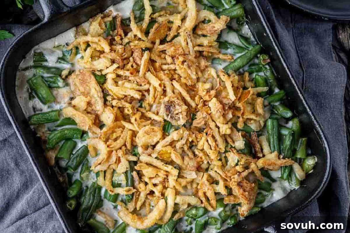 A casserole dish filled with green beans, creamy sauce, and topped with crispy fried onions.