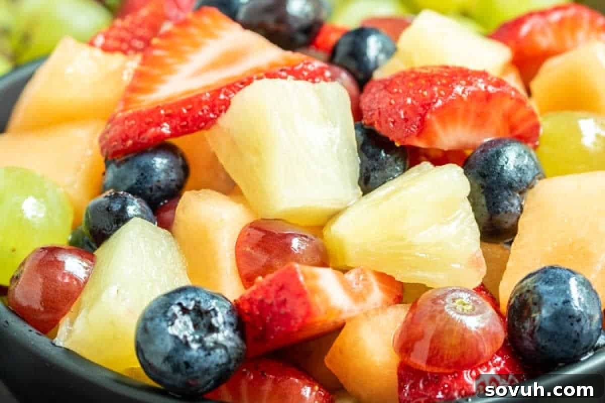 Close-up of a mixed fruit salad featuring strawberries, pineapple, blueberries, grapes, and melon chunks in a bowl—perfect for an Easter brunch favorite.