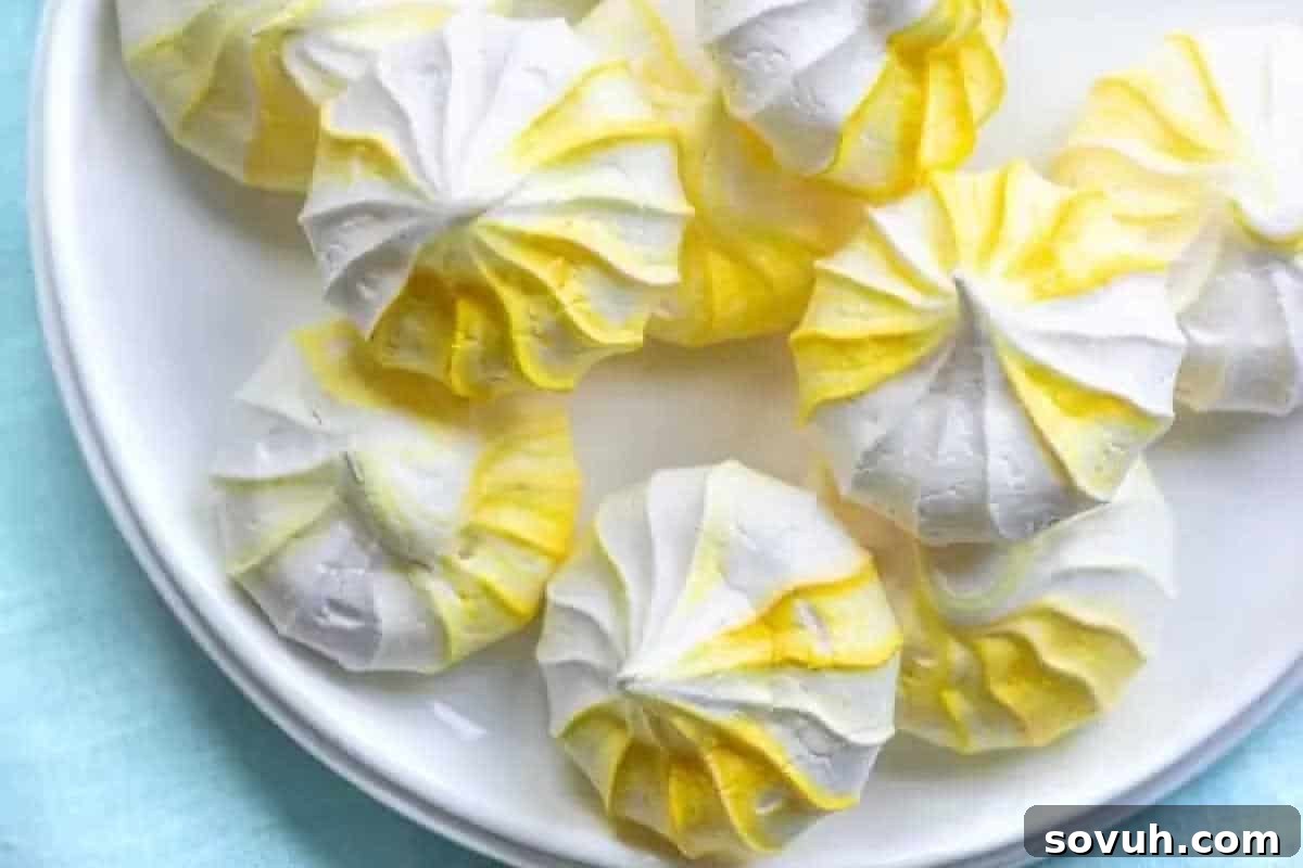 Whimsical Easter Treats Made Simple 7 Plate of yellow and white swirled meringue cookies on a light blue surface.