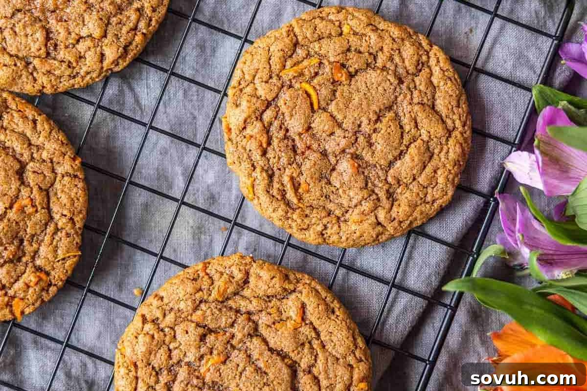 Whimsical Easter Treats Made Simple 8 Cookies on a cooling rack next to a bouquet of purple and orange flowers.
