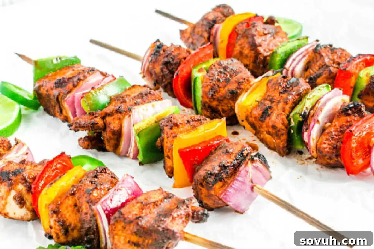 Beautifully arranged Grilled Chicken Fajita Skewers, showcasing tender, marinated chicken pieces intertwined with colorful bell peppers and onions, perfectly charred from the grill. These skewers are presented invitingly, highlighting their savory flavors and vibrant appearance, ideal for easy serving at any gathering.