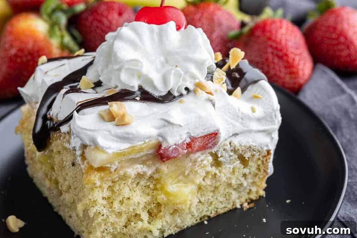 A slice of cake topped with whipped cream, a cherry, chocolate sauce, chopped nuts, and strawberry slices on a black plate, with whole strawberries in the background.