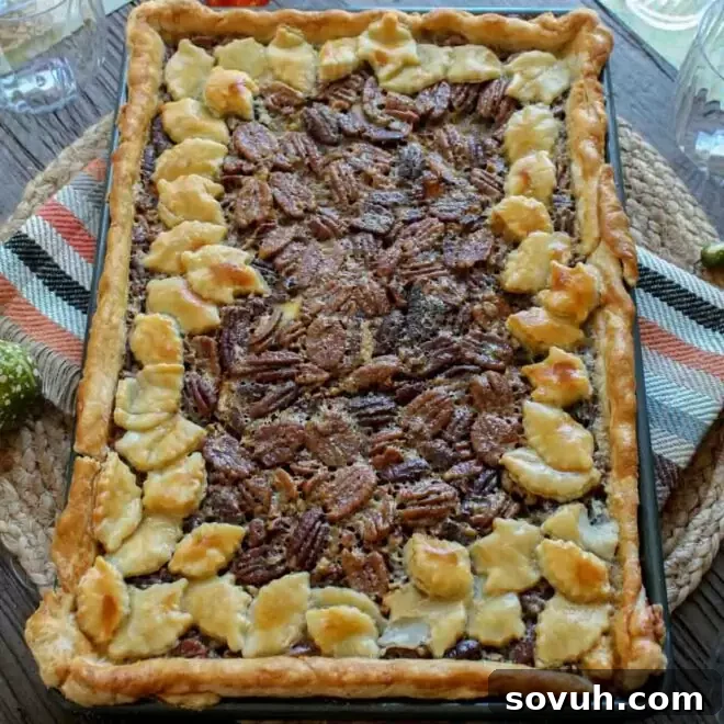 A large Pecan Slab Pie in its baking pan on a table, ready for serving a crowd.