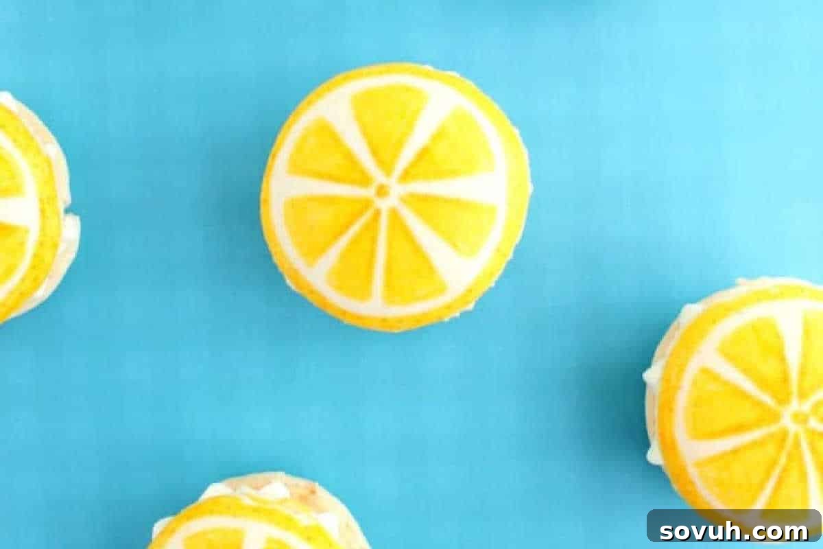Four round cookies decorated to look like lemon slices are arranged on a bright blue background.