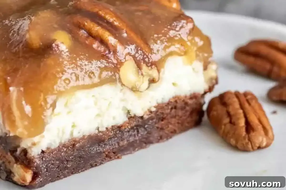 A close-up of a luxurious dessert bar featuring a fudgy brownie base, a smooth cheesecake layer, a glistening caramel topping, and whole pecans, beautifully presented on a white plate with extra pecans.