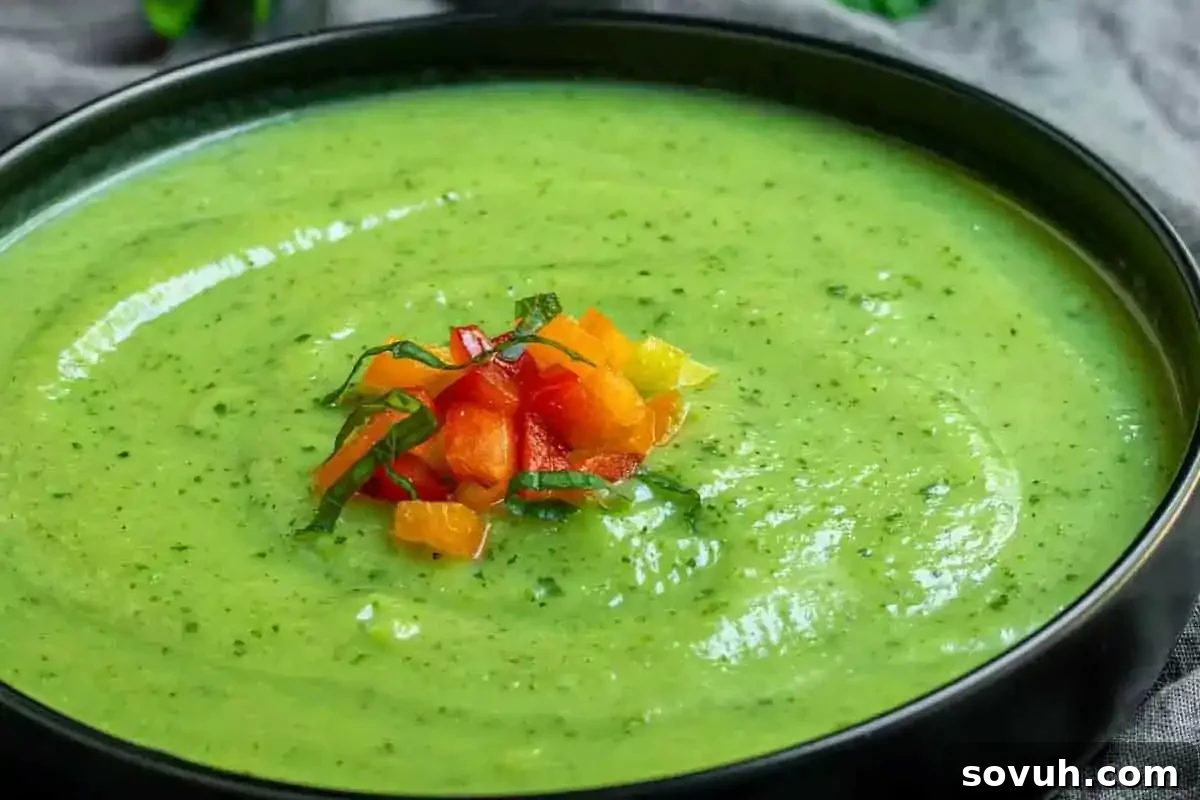 A beautifully presented bowl of creamy, verdant green zucchini soup, inspired by the most creative zucchini recipes, elegantly garnished with finely chopped vibrant red and yellow bell peppers and fresh herbs in the center, inviting a delightful culinary experience.