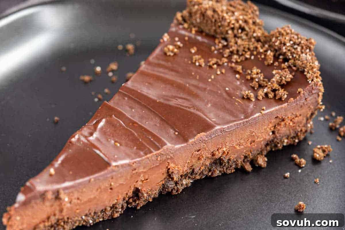 A slice of chocolate cheesecake with a chocolate crumb crust on a black plate—perfect for those seeking easy recipes and simple cooking delights.