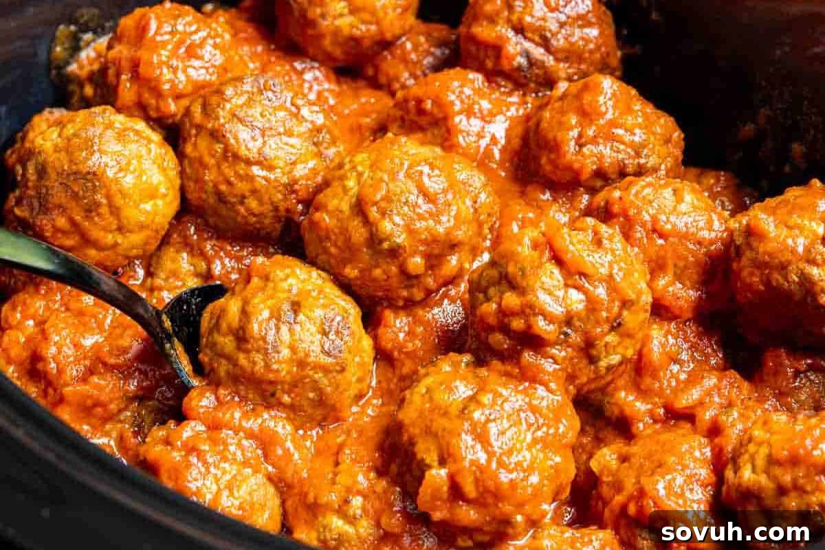Close-up of perfectly coated Frozen Meatballs in a rich tomato sauce, served in a dish with a spoon—an effortless fall meal or party appetizer.