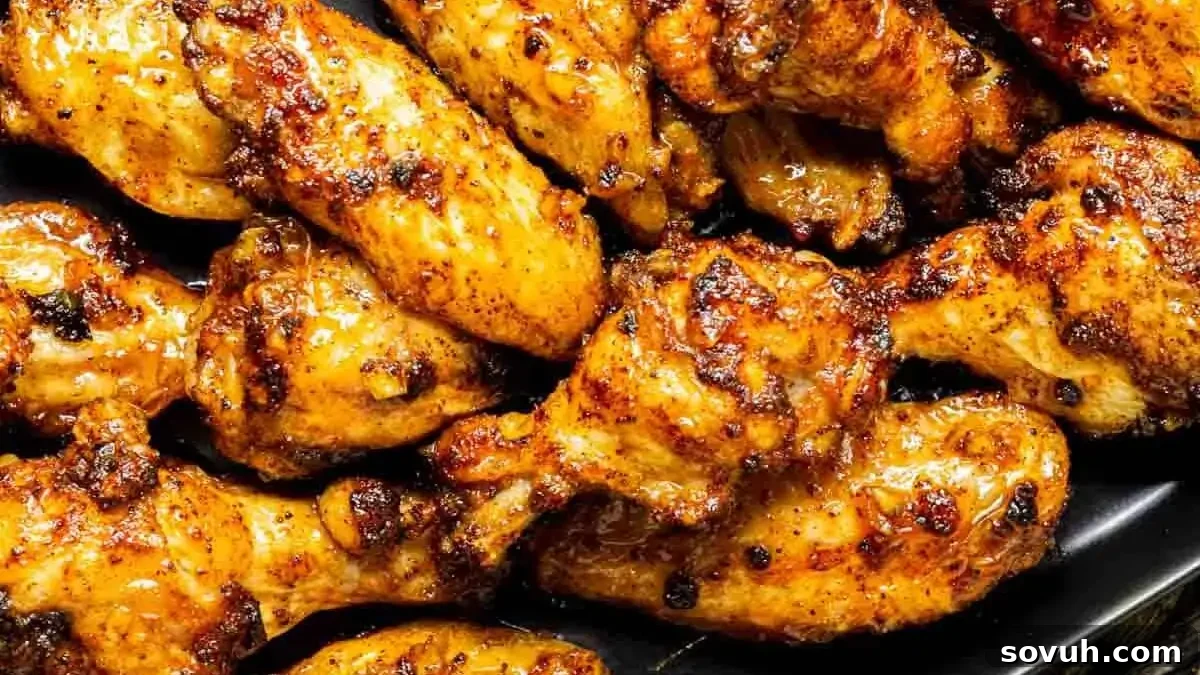 A plate of glazed and seasoned chicken wings garnished with fresh parsley.