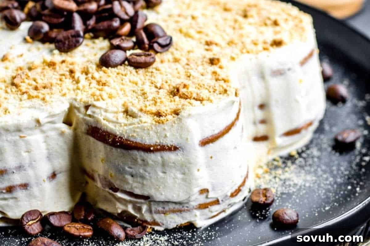 Classic Bolo de Bolacha, a traditional Portuguese biscuit cake with layers of Maria biscuits, rich coffee, and creamy buttercream, presented on a black plate.