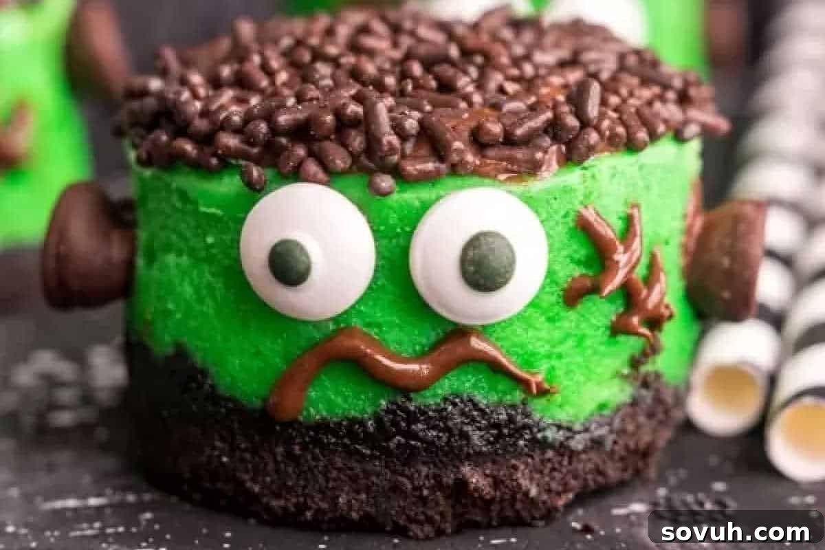 A spooky Frankenstein-themed cake with green frosting, chocolate sprinkle hair, chocolate eyes, and a squiggly mouth, surrounded by striped straws. Perfect for fun Halloween treats that delight and thrill every guest!