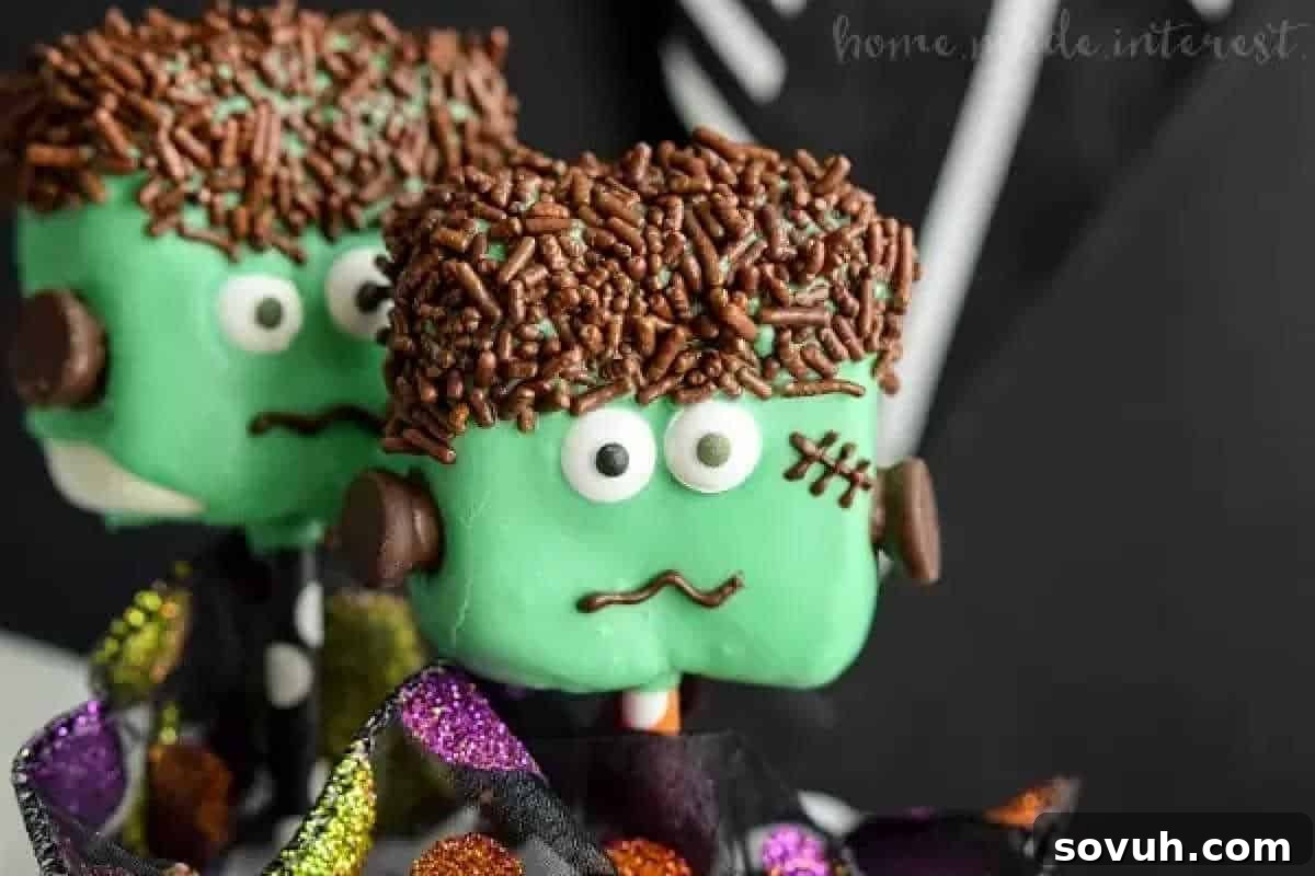 Two green Halloween-themed cake pops with chocolate sprinkle hair, candy eyes, and decorated to look like Frankenstein's monster.