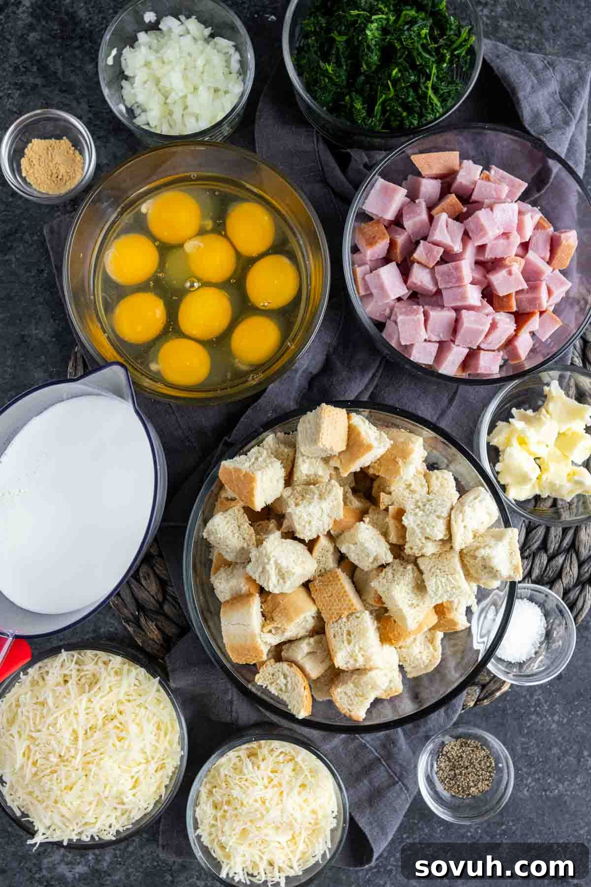 A bowl of eggs, bread, ham, cheese and other ingredients to make Ham and Cheese Strata
