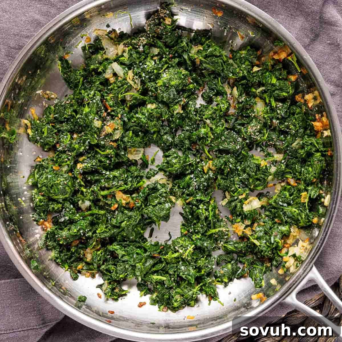 spinach cooked in a pan on a cloth for Ham and Cheese Strata