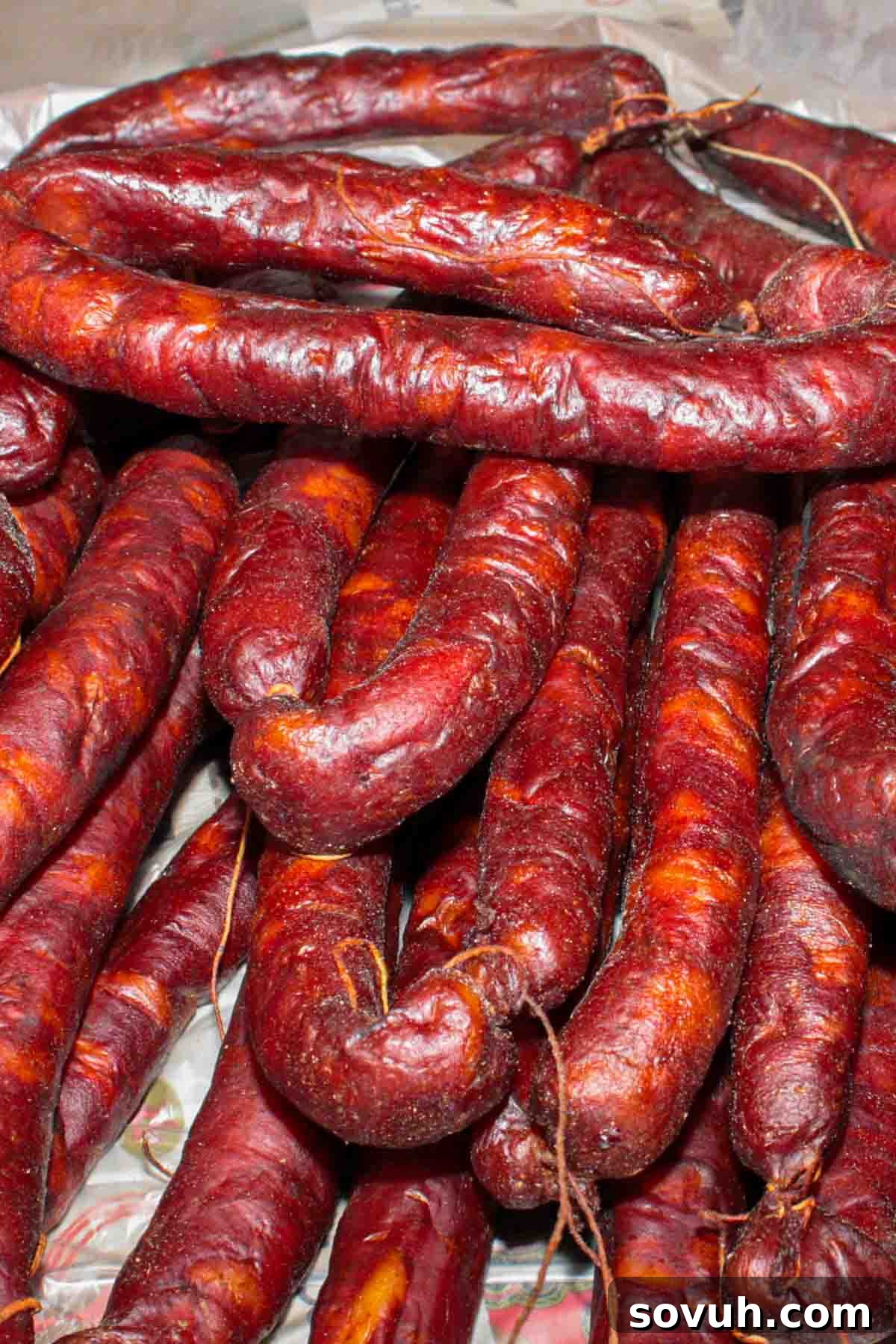 A pile of expertly dried Portuguese sausage on a wooden table, ready for consumption