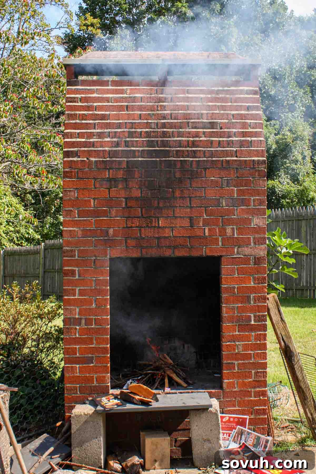 A traditional brick fireplace actively smoking Portuguese sausage, illustrating the authentic smoking process