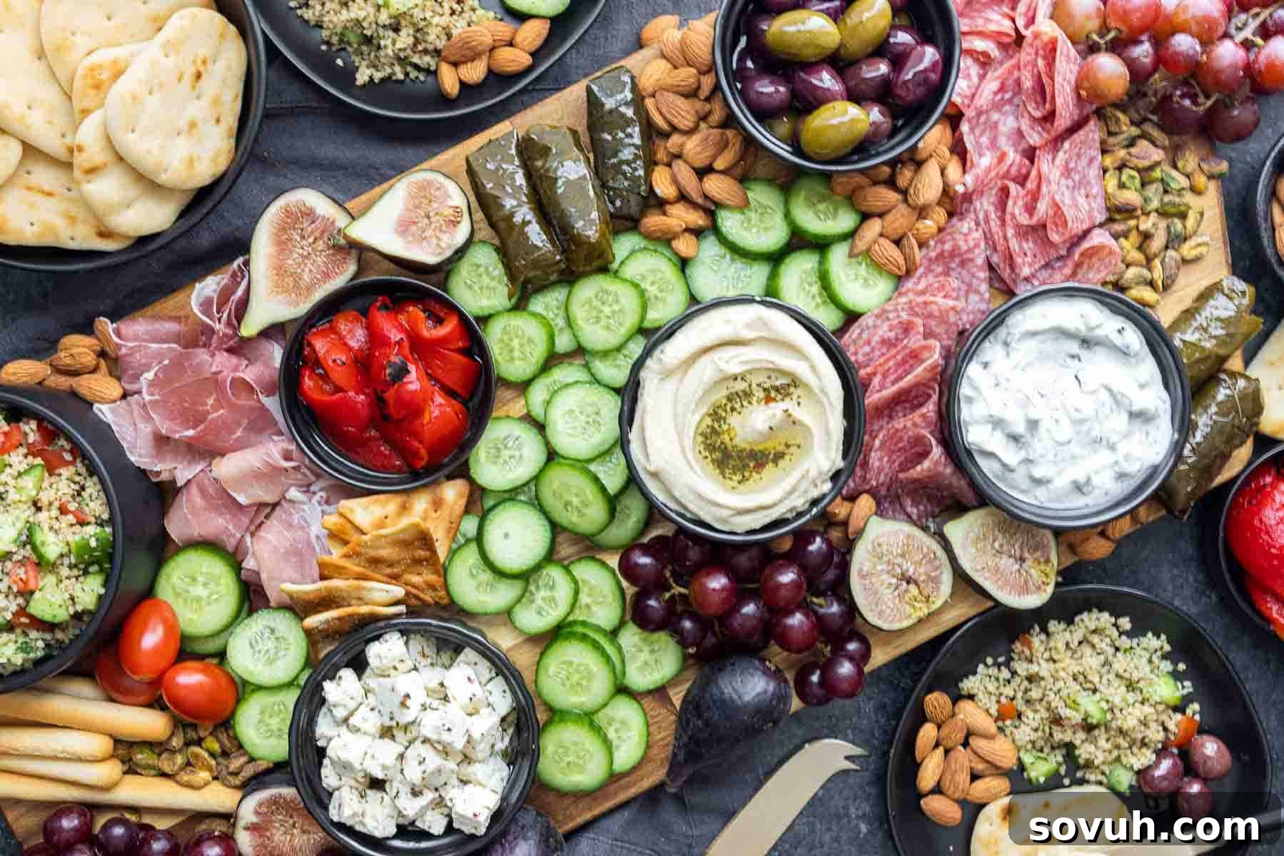 Vibrant Mezze Platter with hummus, pita bread, assorted cheeses, cured meats, fresh vegetables, olives, and nuts, arranged on a wooden serving board for Friendsgiving.