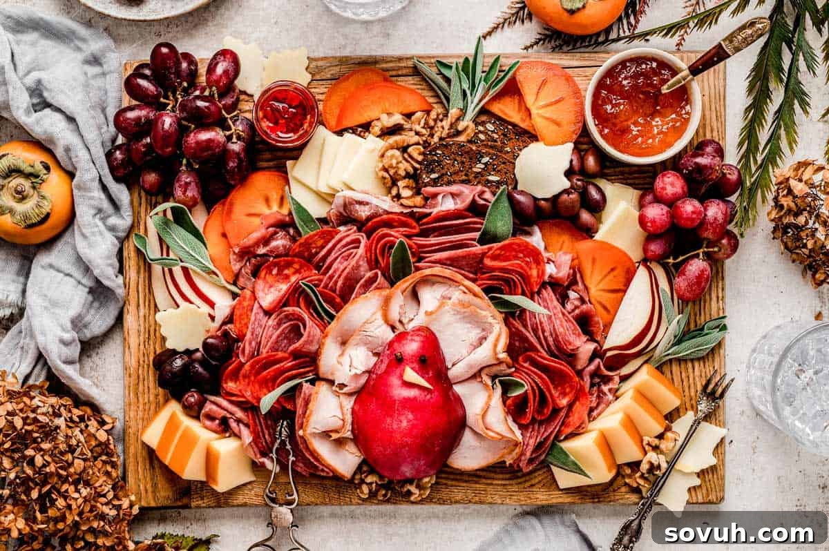 A festive Thanksgiving Turkey Charcuterie Board featuring assorted sliced meats and cheeses arranged as turkey feathers around a central pear body, complemented by grapes, persimmon slices, walnuts, crackers, and a whole pomegranate.